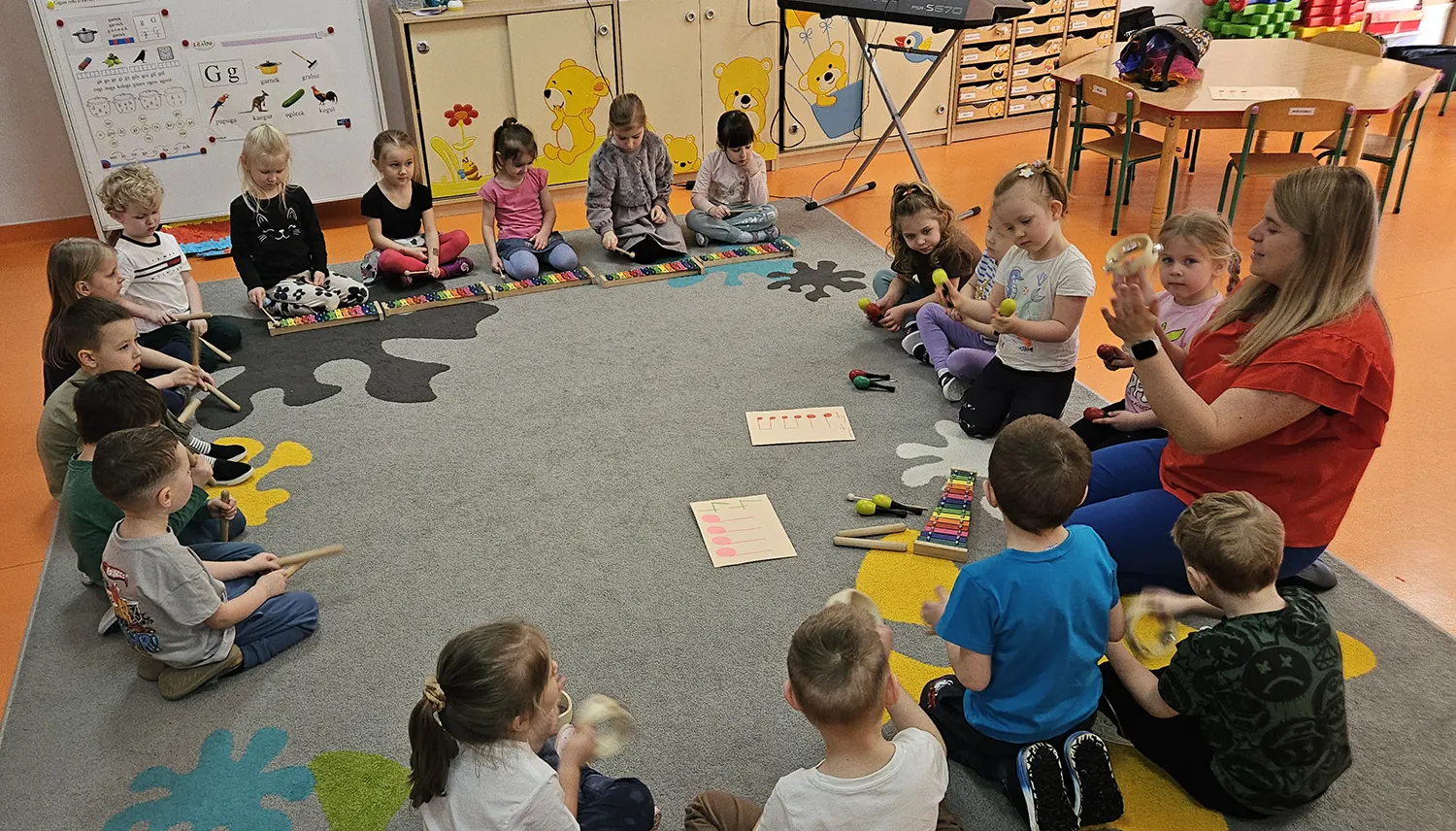  Dzieci siedzą z wychowawc...