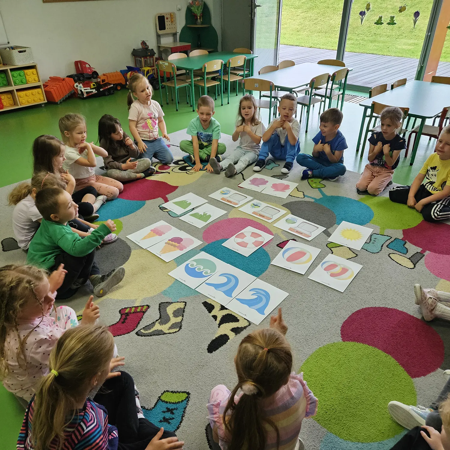  Dzieci siedzą na wykładzi...