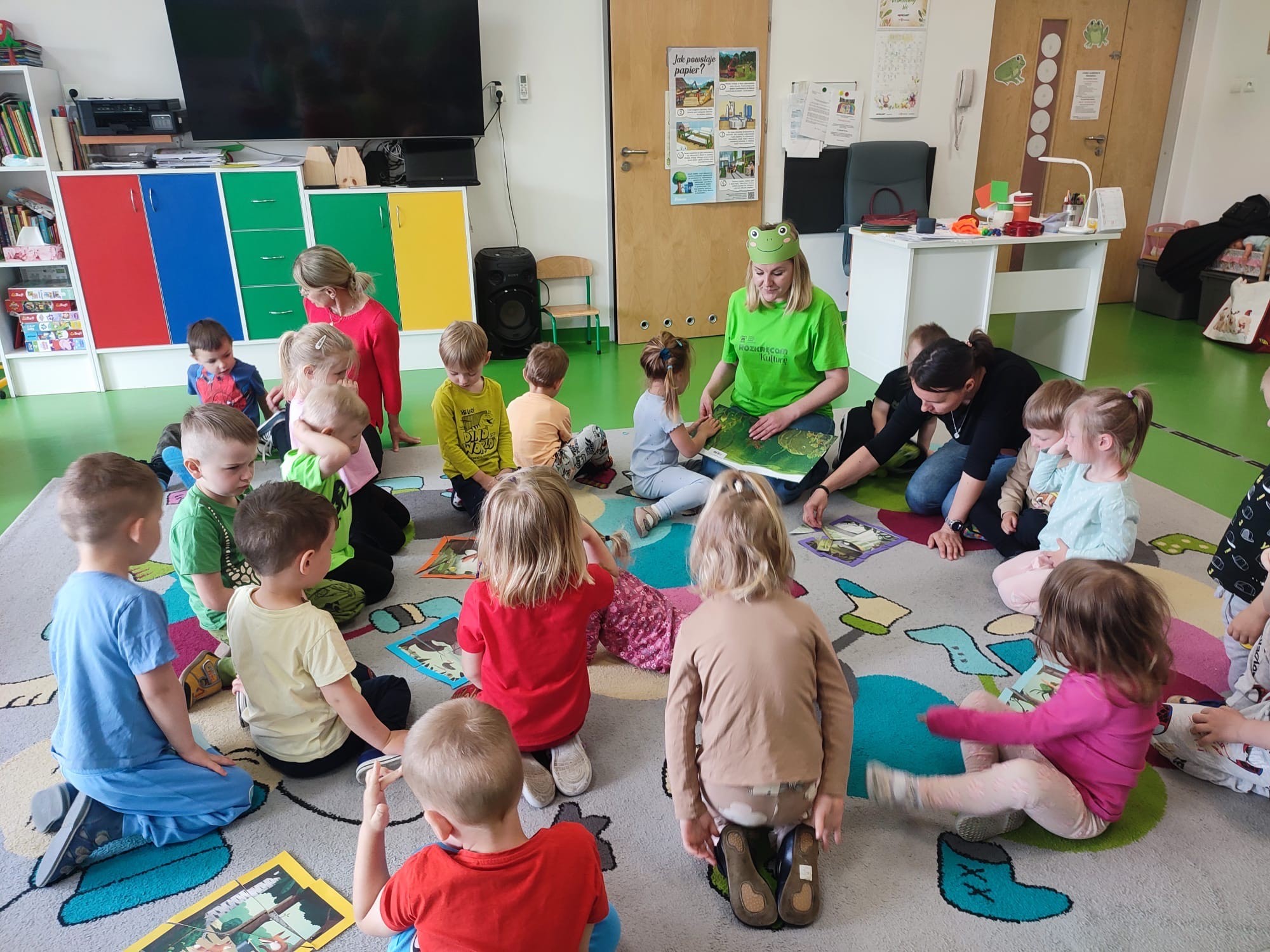  Dzieci siedzą z osobą dor...