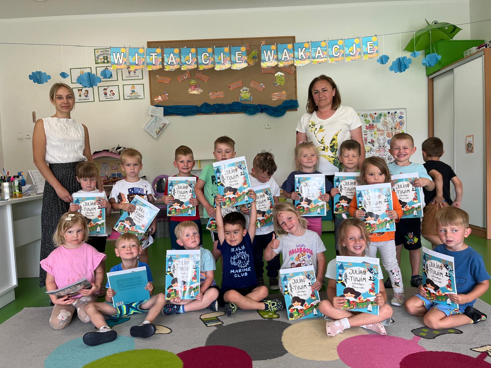  dzieci siedzą na podłodze