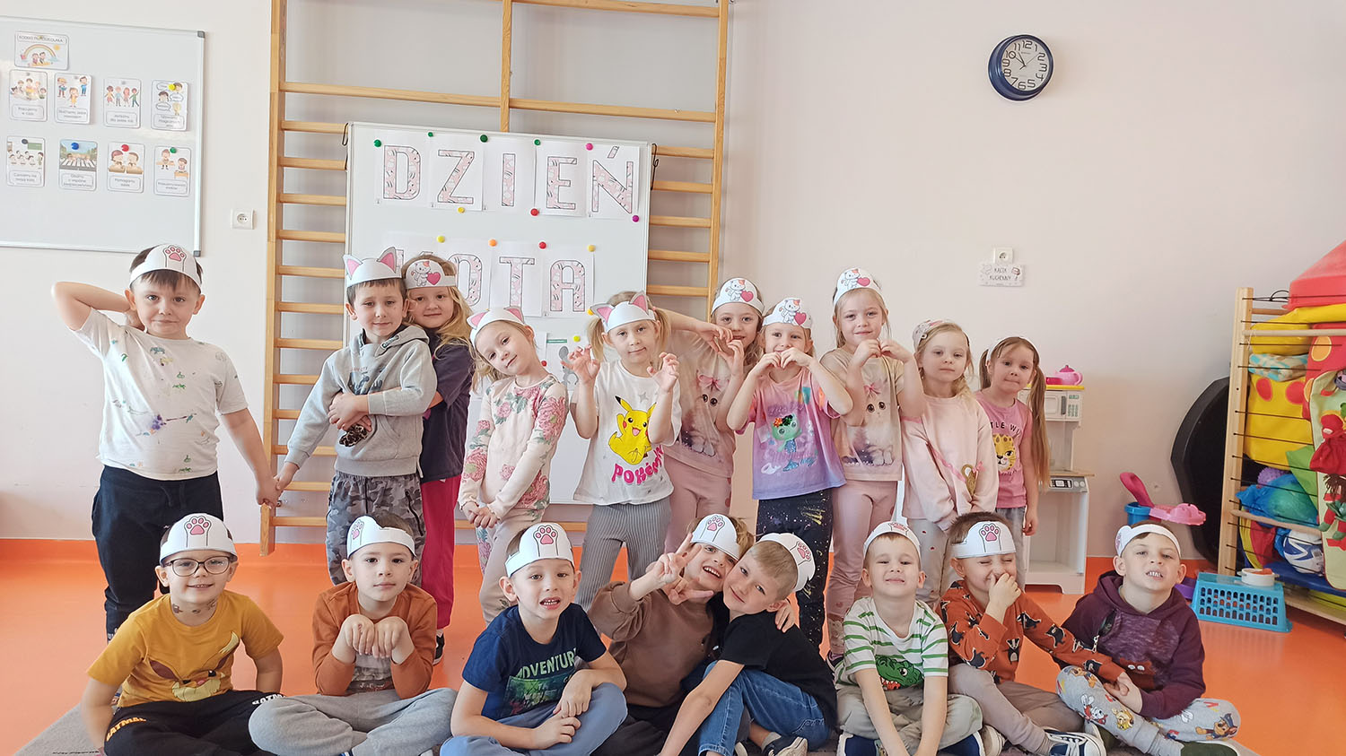  dzieci stoją i siedzą